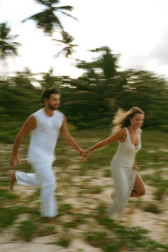 Un couple court main dans la main sur la plage